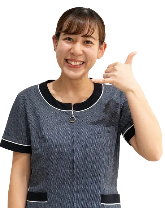電話のしぐさをする笑顔の歯科総合職スタッフ