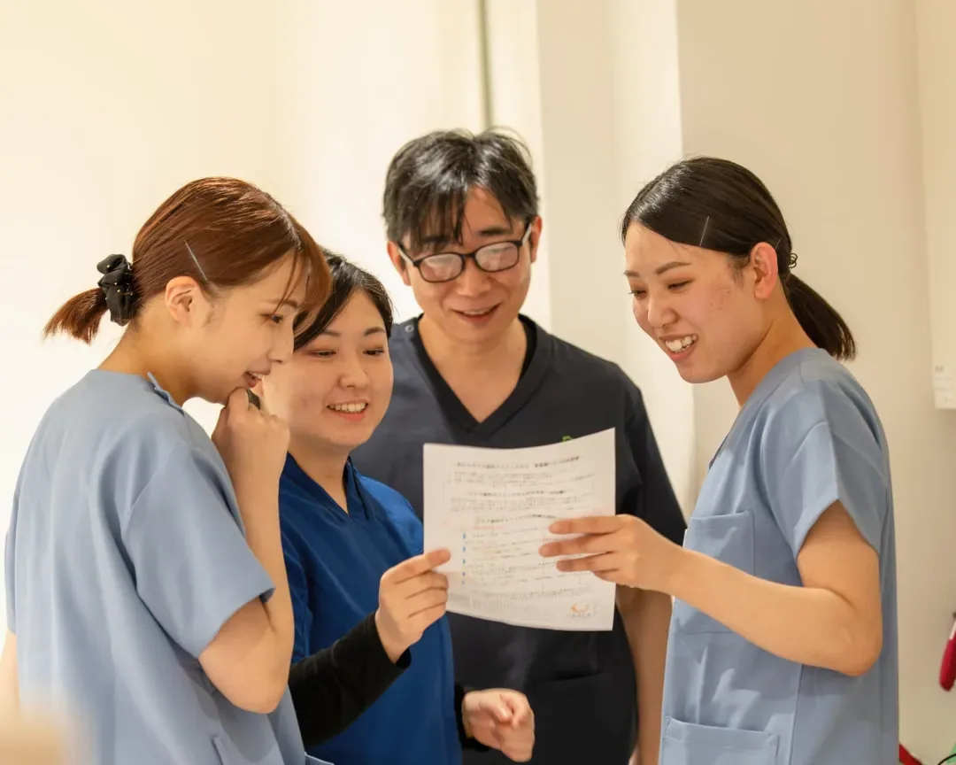 書類を見ながら笑顔で話すスタッフ4人