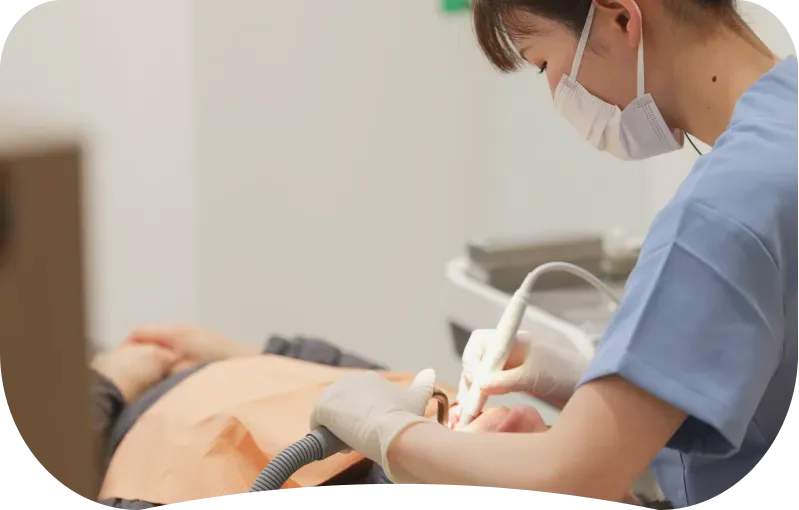 器具を使って患者様を処置する歯科衛生士