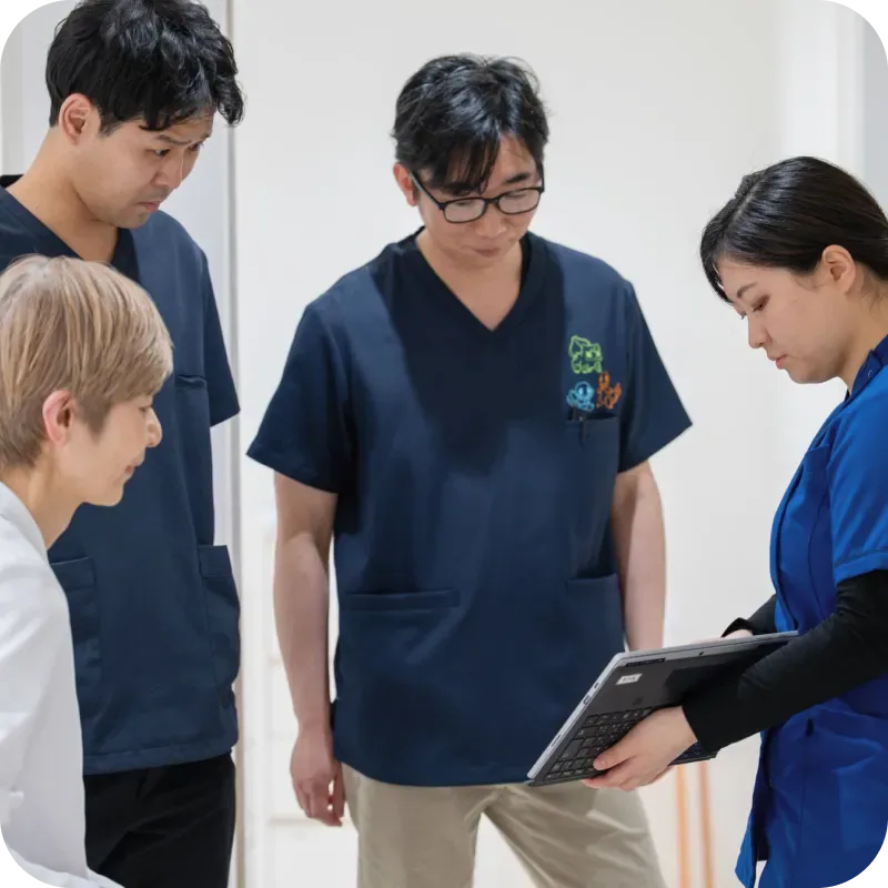 タブレットを囲んで話し合うスタッフ4人