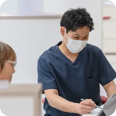 患者様の前でタブレットに書き込むスタッフ
