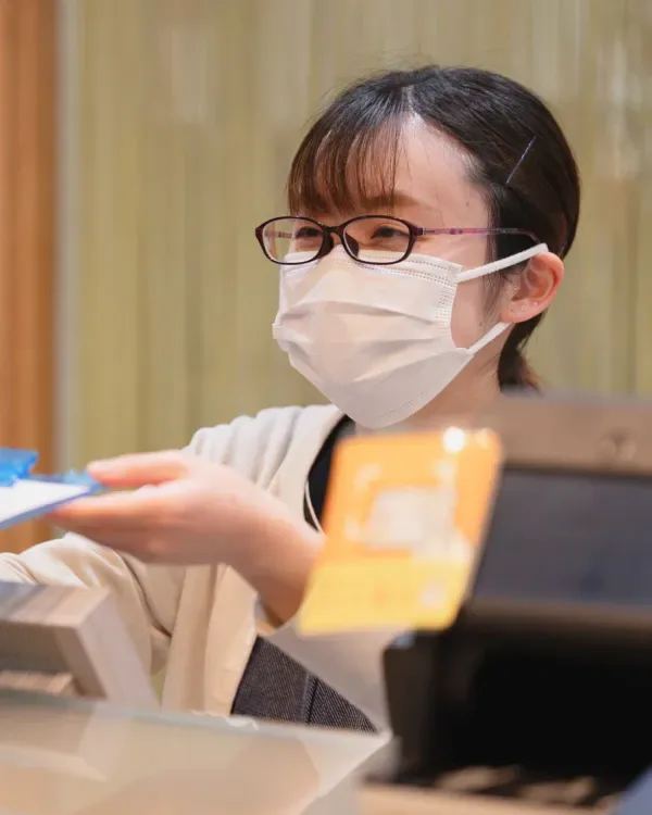 受付カウンターで対応するスタッフ