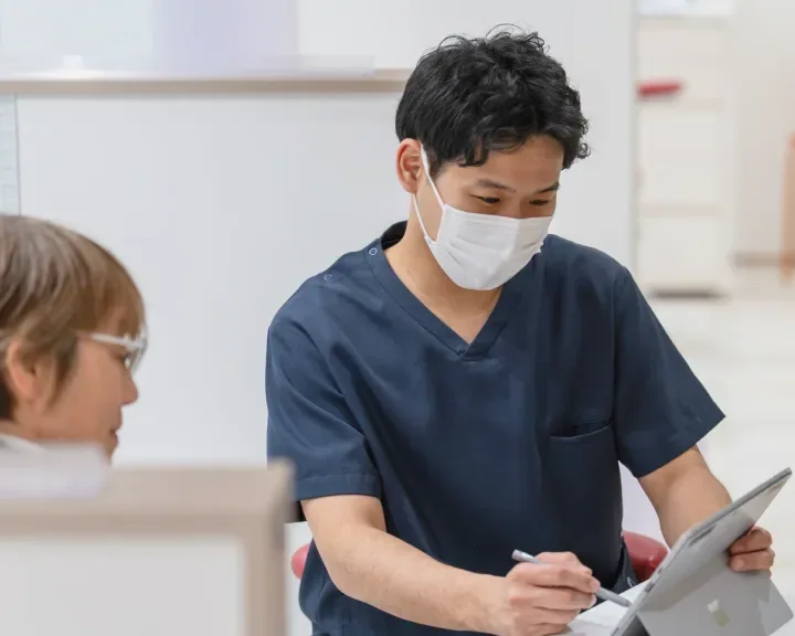 患者様の前でタブレットに書き込むスタッフ