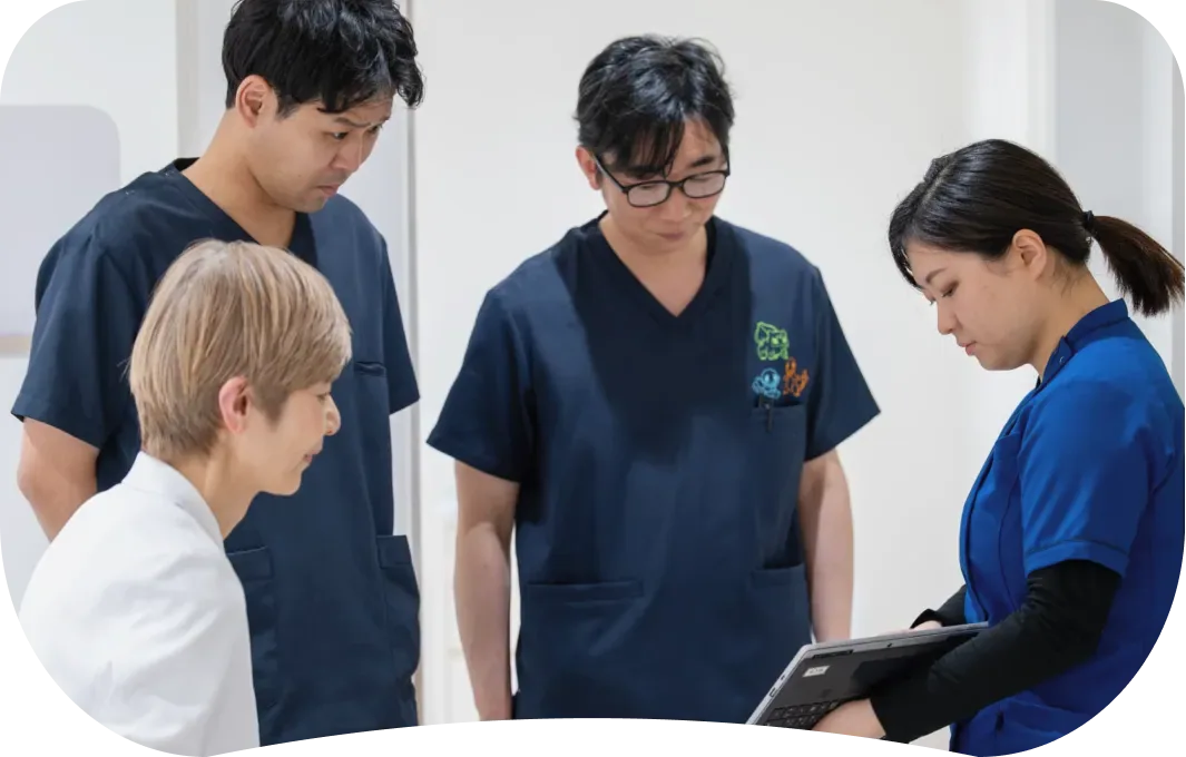 タブレットを囲んで話し合うスタッフ4人